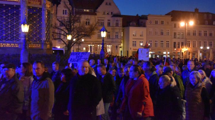 Menschen demonstrieren in Wismar + Schild „Nieder mit der Regierung“