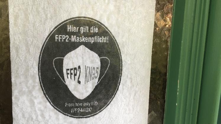 Ein Schild an der Eingangstür der Praxis von Hausarzt Michael Herbst in Rehna weist auf die FFP2-Maskenpflicht hin.