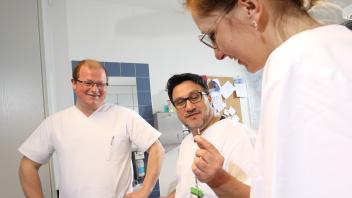 Oberarzt Dr. Basil Alkhlout  zeigt im  Klinikum  Karlsburg den Pflegekräften Stephan Böttcher  (links)  und Janine  Watzelhan den büroklammergroßen  Sensor.