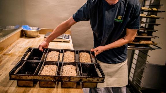 <p>Die Arbeit mit Ressourcen aus biologischen Anbau ist besonders herausfordernd: Bäcker-Geselle Marcel Dähne schiebt die Backformen mit dem Dinkelganzkornbrot in den Backofen. Foto: Zacharie Scheurer/dpa-tmn - ACHTUNG: Nur zur redaktionellen Verwendung im Zusammenhang mit dem genannten Text</p> Bäcker-Geselle Marcel Dähne