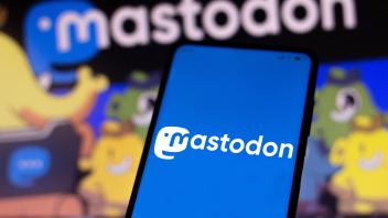 April 21, 2022, Brazil. In this photo illustration, a woman holds a smartphone with the Mastodon logo displayed on the s