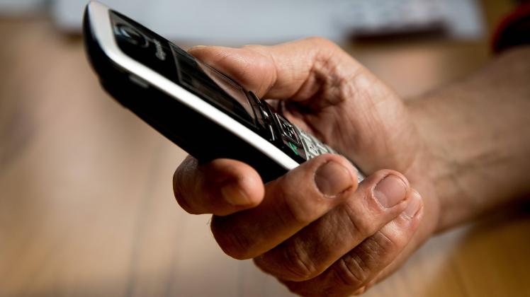 Bamberg, Deutschland 29. April 2021: Die Hand eines älteren Menschen hält ein Telefon, Mobilteil in der Hand. Viele Seni