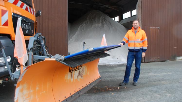 Der Leiter der Straßenmeisterei Perleberg des Landesbetriebs Straßenwesen, Christian Höger, zeigt ein Streufahrzeug vor dem mit 800 Tonnen gefüllten Salzlager. 