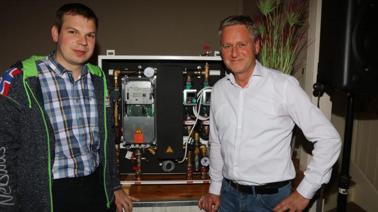 Martin Kopp (rechts), Experte für Nahwärmenetze, Jens Dau von Dau Energie, der ein Nahwärmenetz in Tetenhusen im Kreis Schleswig-Flensburg aufgebaut hat, zeigen eine der notwendigen Wärmeübertragerstationen.
