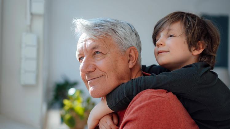 Thoughtful boy embracing grandfather from behind at home model released, Symbolfoto property released, JOSEF12225