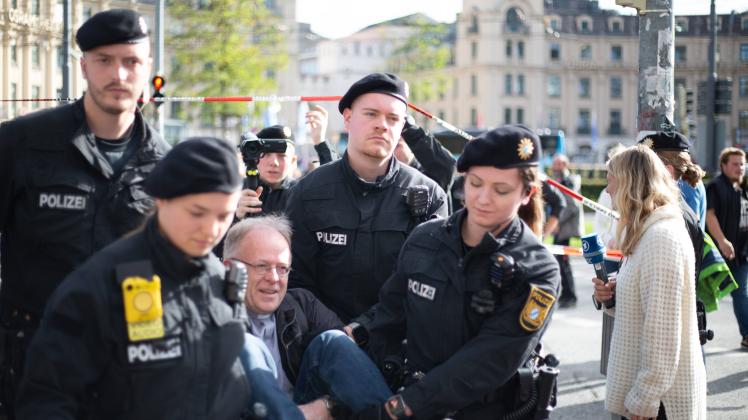 Klima-Aktivist*innen um Jörg Alt kleben sich auf die Straße Jesuiten Pater Jörg Alt wird abtransportiert. Am 28. Oktober