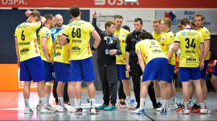 Die Interimstrainer Florian Zemlin (mit dem Arm nach oben) und Tristan Staat (rechts daneben) in einer Besprechung mit der Mannschaft des HC Empor Rostock.