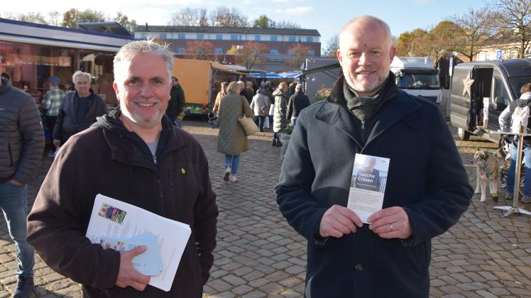 Sie treten gegeneinander zur Stichwahl ums Bürgermeisteramt an, doch vorher beantworten Sascha Clasen (v.r.) und Sven Radestock auf dem Wochenmarkt Fragen der Wähler.