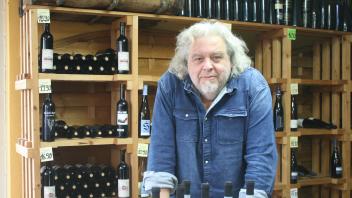 Matthias Fischer-Willwater hat mit „Willwaters Weinladen“ eine Institution für Freunde des guten Tröpfchens geschaffen. Im Regal links hinter ihm liegen seine eigenen Weihnkerationen im Angebot.