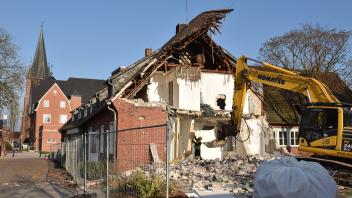 Eine Hausecke der ehemaligen Feuerwehrtechnischen Zentrale im Süden des Papenburger Rathauses ist bereits abgebrochen worden. Im Inneren entfernen Bauarbeiter nun die Dämmung. 