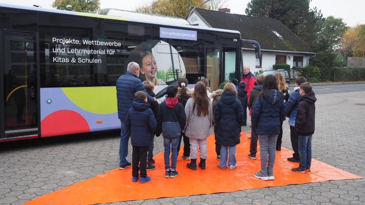 Verkehrslehrer und Vorsitzender der Kreisverkehrswacht Pinneberg Gerd Vollstedt (links) und Busfahrer Ernst-Niko Koberg (vorn) erklärten den Kindern den „Toten Winkel“ beim Bus.