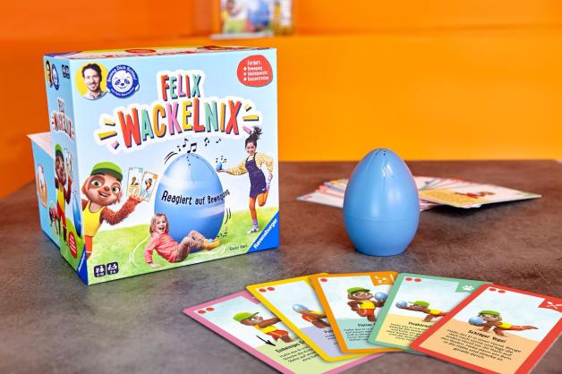 Zum Spiel „Beweg dich schlau! Felix Wackelnix“ gehören ein Wackel-Ei und bunte Karten mit Bewegungs- und Denkaufgaben.