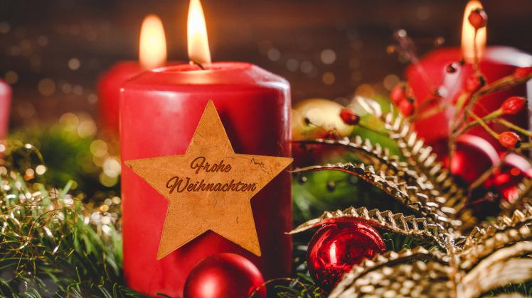 Bavaria, Germany - 10 November 2022: red candle on an Advent wreath at Christmas with a golden star with the inscription