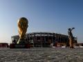 TOPSHOT - A man takes a picture in front of a replica of the World Cup trophy outside the Stadium 974 in Doha on November 15, 2022, ahead of the Qatar 2022 World Cup football tournament. (Photo by Kirill KUDRYAVTSEV / AFP)