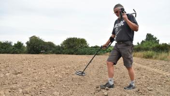 Bodendenkmalpfleger Friedhelm Zedler sucht historische Gegenstände im Erdboden.