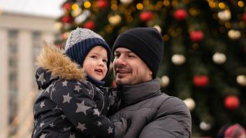 Smiling man carrying son at Christmas market model released, Symbolfoto, SSGF00968