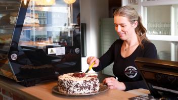 Hannah Kotulla schneidet einen der vielen Torten an. Jeden Sonntag hat das kleine
 Café in Bögelhuus von 14:00 bis 18:00 Uhr geöffnet.