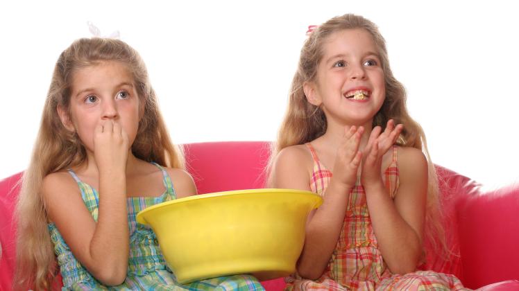 children watching a movie laughing & eating popcorn PUBLICATIONxINxGERxSUIxAUTxONLY Copyright: 30303771