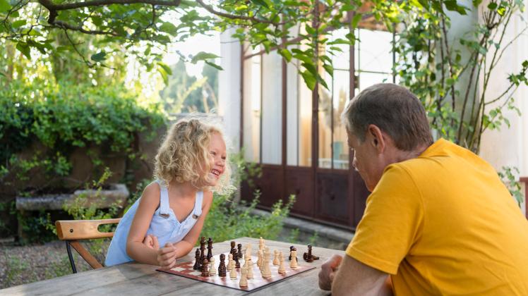 Granddaughter and grandfather playing chess in garden model released, Symbolfoto property released, SVKF00601