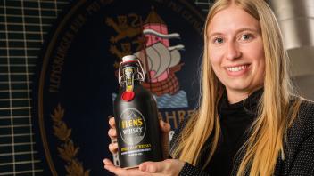 Nadina Andersen von der Brauerei zeigt die Whisky-Flasche mit typischen Plopp-Bügel