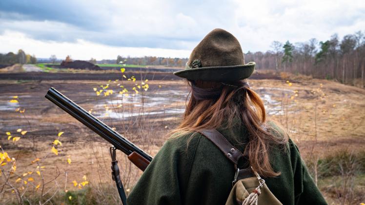 Jagd und Wildhege, junge Jägerin steht auf einem Jagdhochsitz. Symbolfoto. Jägerprüfung - immer mehr Frauen entdecken fü