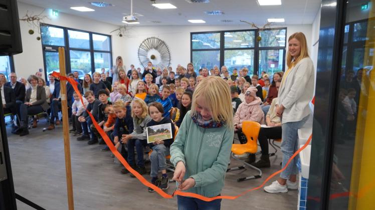 Schülerin Jette Kolmes durchschneidet das rote Band und eröffnet so offiziell das neue Mehrzweckgebäude der Castellschule in Lingen.