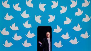 (FILES) This file photo illustration taken on August 05, 2022, shows a cellphone displaying a photo of Elon Musk placed on a computer monitor filled with Twitter logos in Washington, DC. - After snapping up Twitter, one of Silicon Valley&apos;s most iconic companies, Elon Musk swiftly introduced his no-holds-barred work ethic, setting up a bitter culture clash with thousands of workers who still believed in the platform&apos;s higher mission. In less than a month, Musk sacked half the company&apos;s 7,500 employees, axed executives and engineers who disagreed with him and finally imposed an ultimatum: work "extremely hardcore" or leave. (Photo by SAMUEL CORUM / AFP)