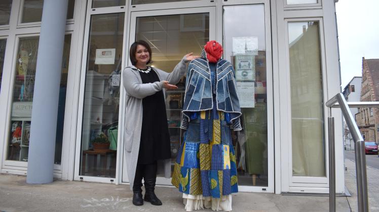 Inna Kirsanova steht vor ihrem Laden mit einer Schaufensterpuppe, die Upcycle Klamotten trägt.
