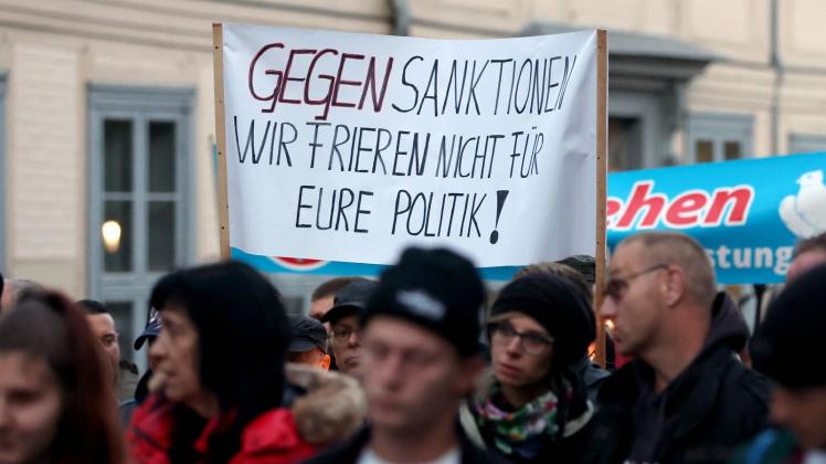 <p>Eine Demonstration gegen die Energiepolitik startet vor dem Schweriner Schloss, auf einem Transparent steht "Gegen Sanktionen Wir frieren nicht für eure Politik!". Foto: Bernd Wüstneck/dpa</p>
