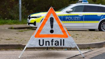 Deutschland 13. Oktober 2022: An einer Straße steht ein faltbares Warndreieck der Polizei mit der Aufschrift Unfall. Im