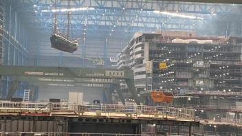 „Luftschiff“ unter dem Dach der Meyer Werft: Beinahe sieht es so aus, dass die „Gesine von Papenburg“ am Kran unter dem Hallendach an dem Ozeanriesen „Carnival Jubilee“ vorbeischwebt.