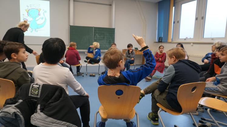 Die Kinder der vierten Klasse der Rosenplatzschule sitzen im Stuhlkreis und lösen eine der gestellten Aufgaben. 