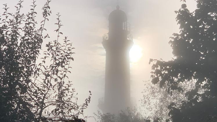 Einen poetischer Anblick bietet der zwischen Sonne und Nebel verhüllte Leuchtturm von Warnemünde. 