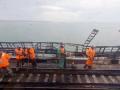This video grab taken from footage provided by a train passenger shows workers restoring the railway tracks on the Kerch bridge that links Crimea to Russia, near Kerch, on October 9, 2022, a day after it was damaged by a blast. - The symbolic bridge inaugurated by Russia&apos;s President Vladimir Putin in 2018,  is logistically crucial for Moscow, a vital transport link for carrying military equipment to Russian soldiers fighting in Ukraine. (Photo by AFP)