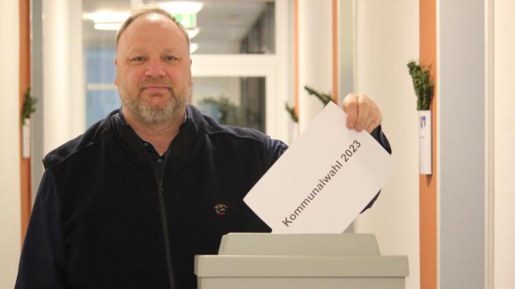 Wahl-Sachbearbeiter Lars Feddersen steht am 2. Dezember 2022 im Flur des Amtes Südtondern vor einer Wahlurne.