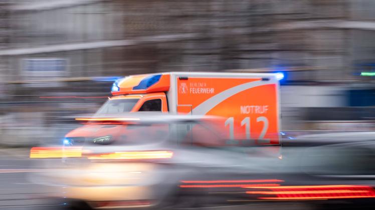 Rettungswagen der Berliner Feuerwehr fährt mit Blaulicht durch Berlin. / Berlin Fire Department ambulance driving throug