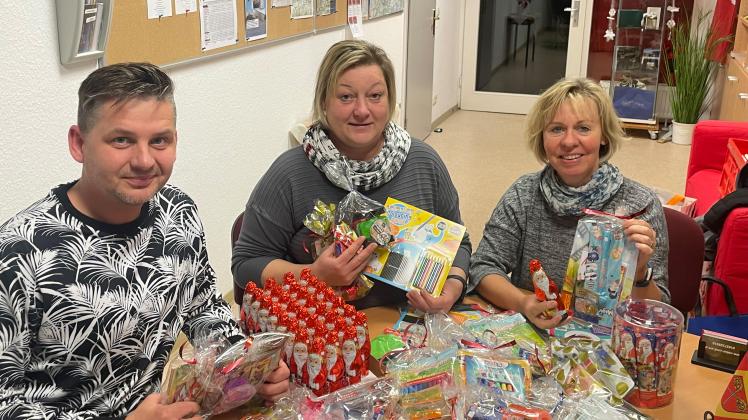 Elmar Pingel, Dorren Kloss, Bärbel Rußbüldt (v.l.) packen Geschenke für die Weihnachtsmanntour in Warin ein. 