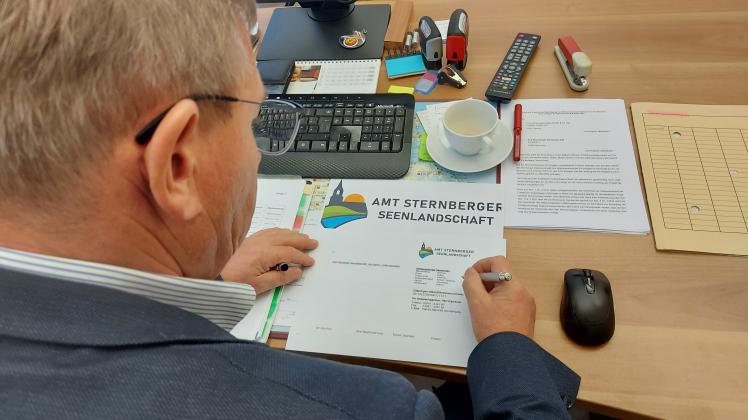 Der leitende Verwaltungsbeamte Armin Taubenheim unterschreibt einen Brief mit dem neuen Amtslogo.