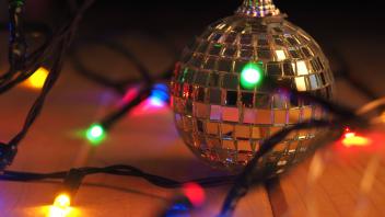 Christmas decoration disco ball on a wooden floor with festive Christmas lights