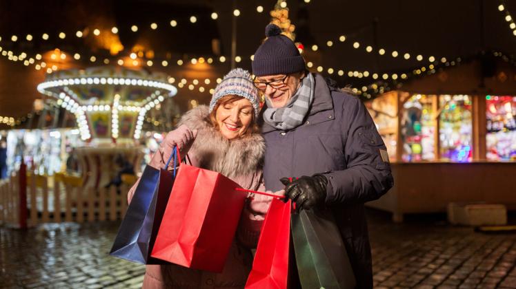old couple at christmas market with shopping bags