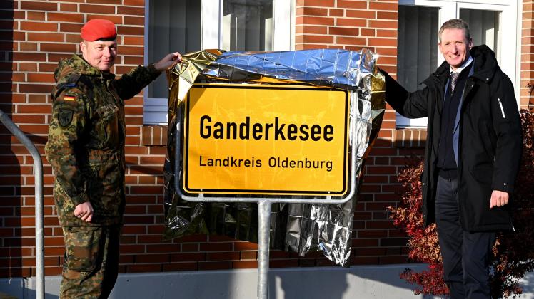 Bürgermeister Ralf Wessel und Oberstleutnant Tobias Schmidt, Kommandeur des Logistikbataillons 163 RSOM, enthüllen in der Delmetal-Kaserne eine Ortseingangstafel mit der Aufschrift „Ganderkesee“.