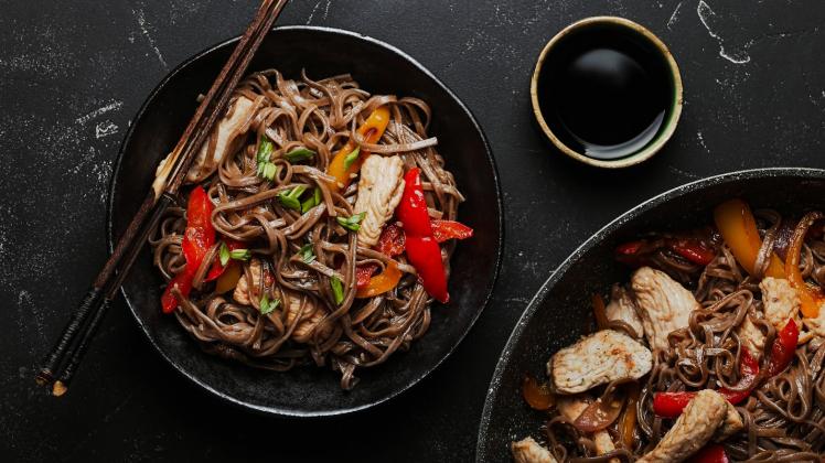 Asian soba chicken noodles Bowl with Asian chicken stir fry soba noodles with vegetables on dark black stone background from above, Chinese Thai or Japanese noodles dish with soy sauce Copyright: xZoonar.com/OlenaxYeromenkox 17722761
