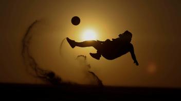 Sport Bilder des Tages A tourist plays soccer in the desert during the FIFA World Cup, WM, Weltmeisterschaft, Fussball 2