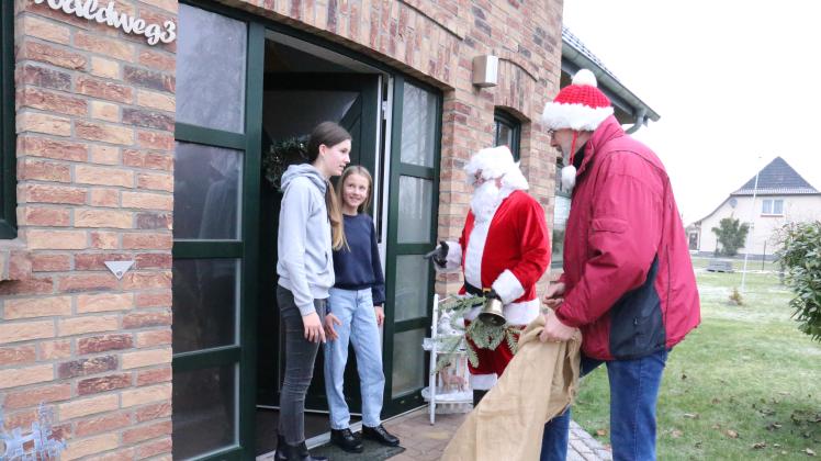 Hier werden Romy und Nele Reinke vom Viezer Weihnachtsmann Dirk Vieth und seinem Gehilfen Holger Fitzner besucht.