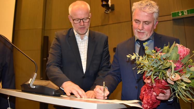 Mit der Unterschrift besiegelt: Sascha Clasen (CDU) überreicht Eutins neuem Bürgermeister Sven Radestock (Grüne, re) nach Unterschrift die offizielle Ernennungsurkunde.  