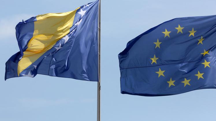 (FILES) In this file photo taken on August 13, 2018, the national flag of Bosnia and Herzegovina (L) is pictured next to the European Union flag during a welcoming ceremony for Bosnia's Chairman of the Council of Ministers, at the Chancellery in Berlin. - EU countries agreed December 13, 2022, to grant Bosnia "candidate status" to join the union, diplomats told AFP, putting the volatile Balkan nation at the start of a long road to membership. European affairs ministers meeting in Brussels gave the green light to the move after the bloc's executive arm in October recommended that they launch the membership process. (Photo by Adam BERRY / AFP)