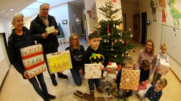 Einige der spendenfreudigen Dissener Kita-Kinder vor dem Verladen mit den Päckchen vor dem Weihnachtsbaum mit (von links) Renate Schulz, Helmut Buschmeyer, Sandra Kundt sowie (rechts) Nicole Rieger.