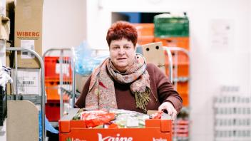 Babette Limp-Schelling trägt Lebensmittel zum Auto, damit sie verteilt werden.