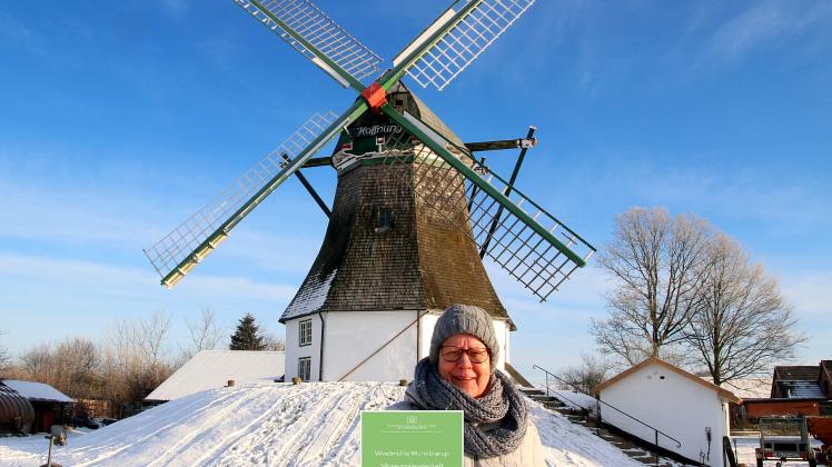 Christel Pagel mit ihrer Zertifizierungsplakette vor der Mühle „Hoffnung“ in Munkbrarup.