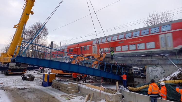 Der große Moment: Das gut zehn Meter lange Stahlskelett der neuen Radwegbrücke wird unter der Eisenbahn-Unterführung per Kran eingesetzt. 